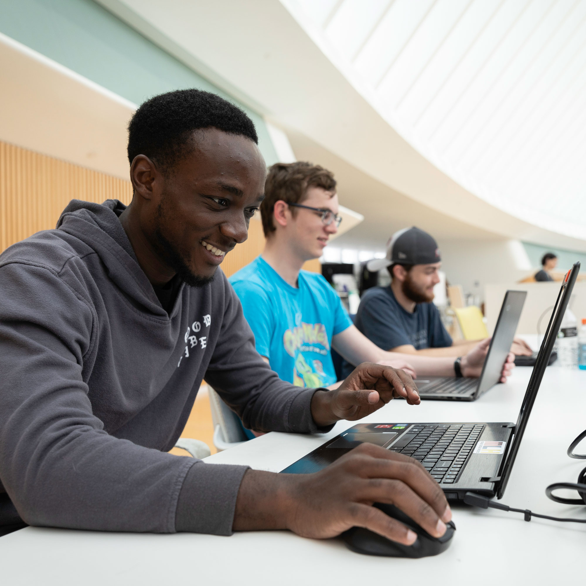 student smiling while working on computer
