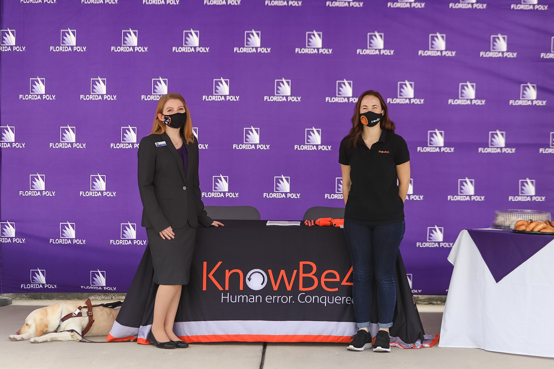 A student and company rep standing in front of a table.