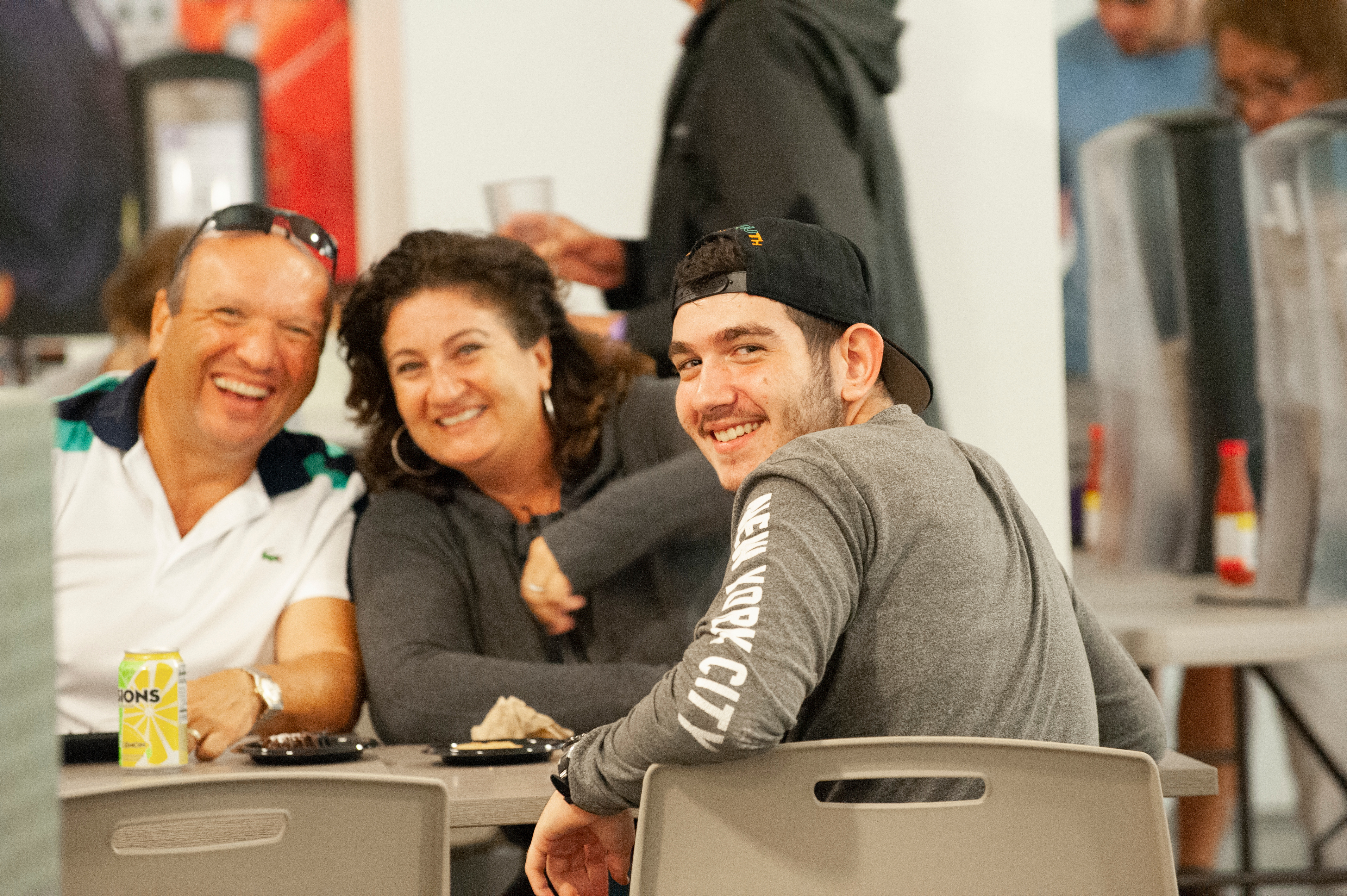 Student and his family sit at a table smiling.