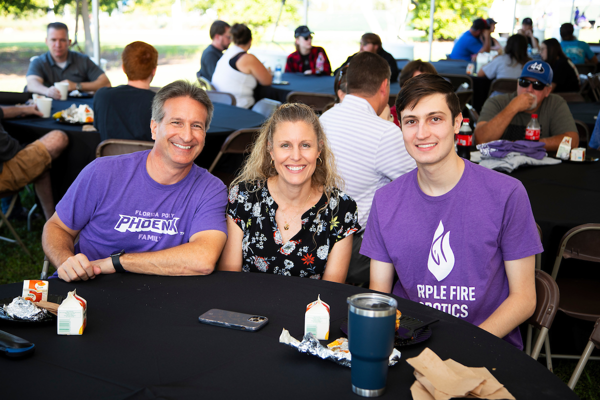 student and parents smiling at table