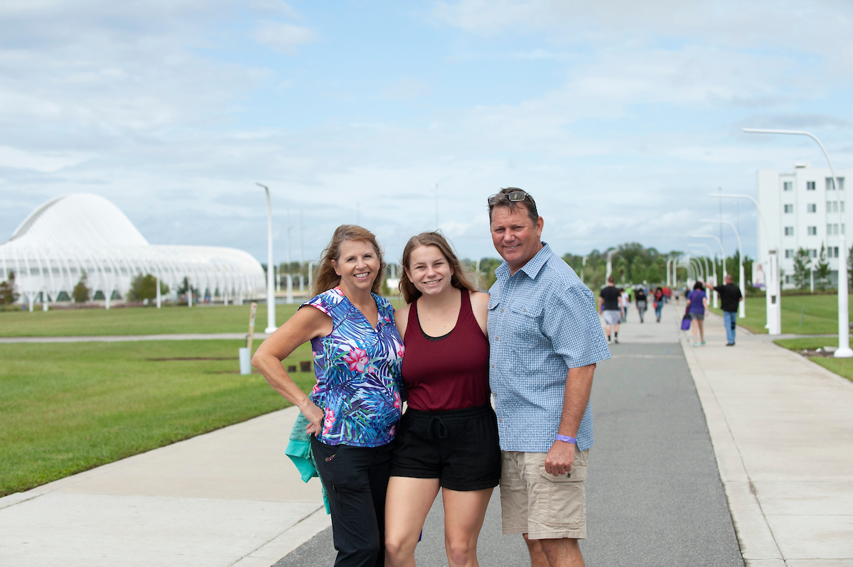 student and her parents smiling